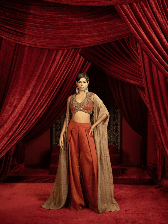 CRIMSON RED QUILTED BLOUSE WITH BOX PLEATED PANTS AND SEPIA BROWN CAPE