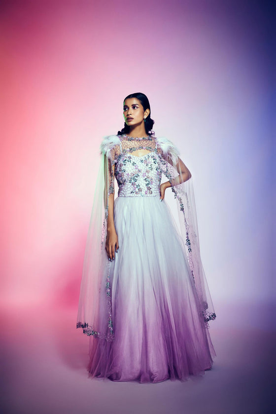 Ombre ball gown with long cape and feather and beads.